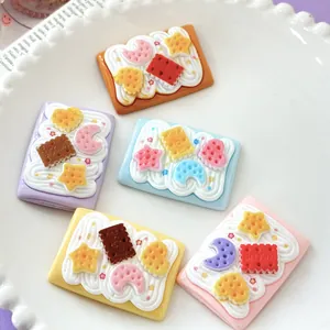 Close-up of large cute simulation cream crackers with star and moon charms for DIY crafts.