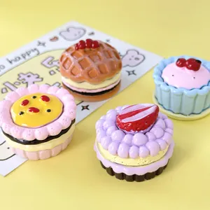 Close-up of miniature colorful resin dessert models including strawberry cake and waffle