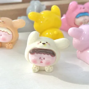Close-up van schattige hars puppybeeldjes met dierenkappen voor DIY bureau decoratie.