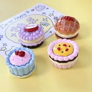 Detailed macro shot of four miniature resin dessert models with vibrant icing details