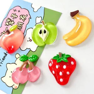Primer plano de dijes de resina de frutas traslúcidas que incluyen fresa y plátano
