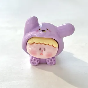 Close-up van een miniatuurhars Liz-beeldje in een paarse puppy-hoodie voor DIY