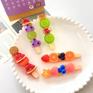 Macro detail of colorful fruit skewer resin charms on a white scalloped plate
