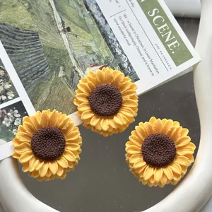Detailed view of yellow resin sunflower charms for DIY craft and phone case decor