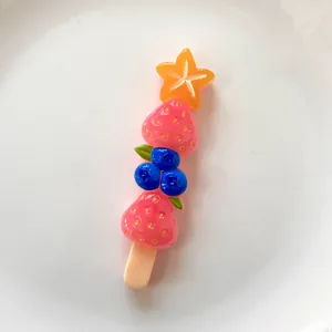 Detailed shot of colorful resin fruit skewer accessory with strawberries for DIY crafts