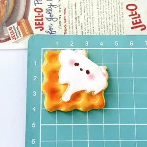 Macro detail of a cute cartoon animal biscuit resin charm for DIY hair accessories.