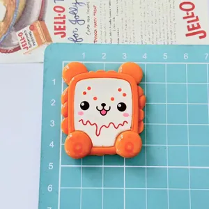 Detail view of large cartoon animal biscuit resin accessory with size scale on blue mat
