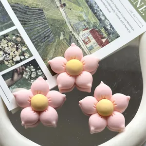 Close-up of pink and yellow resin flower accessories for DIY crafts and phone case decor