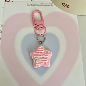 Détail d'un porte-clés en résine étoile gaufre rose avec glaçage blanc mignon.