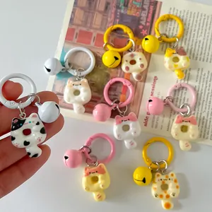 Close-up view of colorful cartoon cat donut keychains featuring matching bells and clips