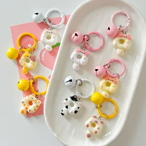 Assorted cute cartoon cat donut keychains with colorful rings and bells on a tray