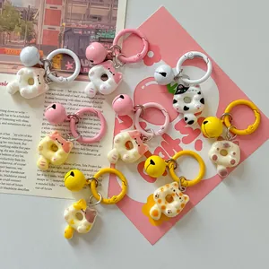 Close-up of cute cartoon donut cat keychains with matching bells as bag charms