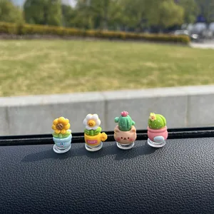 Primer plano de cuatro macetas en miniatura decorativas para el tablero del coche