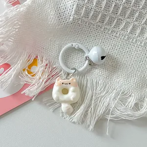Detail view of a cute cartoon cat donut keychain accessory featuring a white bell