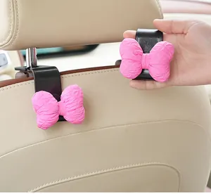 Close-up detail of cute pink bow car headrest hooks installed on seat back accessory