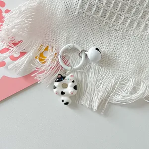 Detailed macro view of a cute cartoon cat donut keychain with a small white bell pendant