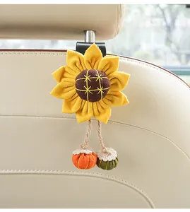 Close-up detail of sunflower car seat back hook with knitted charms on beige leather