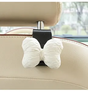 Close-up of a cute white textured bow hook attached to a car headrest pole