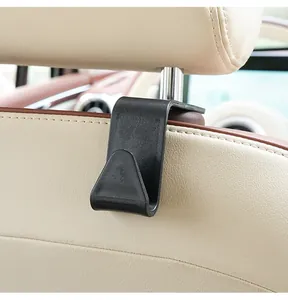 Close-up of black car seat back hook installed on headrest pole for storage