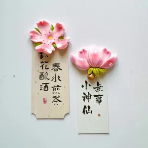Close-up detail of artistic 3D floral fridge magnets with traditional Chinese calligraphy paper cards