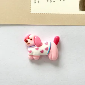 Close-up of pink resin dog accessory with heart pattern sweater for DIY crafts.