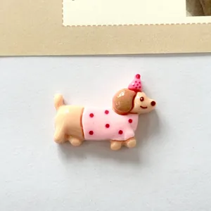 Cute resin dachshund charm with pink polka dot outfit and party hat for DIY crafts