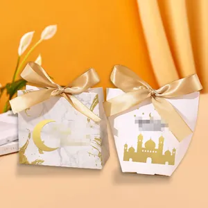 Close-up of elegant gold-stamped white and marble gift boxes with champagne ribbons