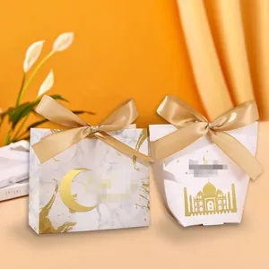Detail of marble and white gift boxes with gold foil castle and moon motifs with ribbons