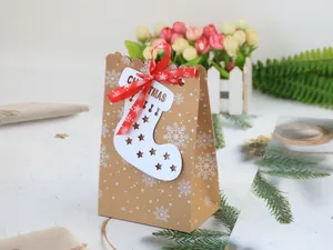 Detailansicht der Weihnachts-Kraftpapiertüte mit Schneeflockenmuster und roter Schleife