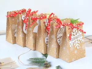 Detailansicht von Weihnachts-Geschenktüten aus Kraftpapier mit roten Bändern und Anhängern.