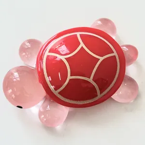 Macro view of a luminous resin turtle ornament featuring a pink body and red shell