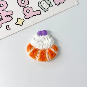 Macro view of a miniature resin pastry accessory with cream and purple berry toppings
