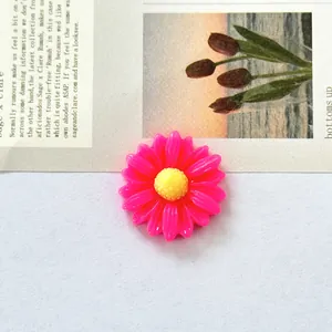 Detailed top view of a pink and yellow daisy resin flatback accessory for DIY crafts