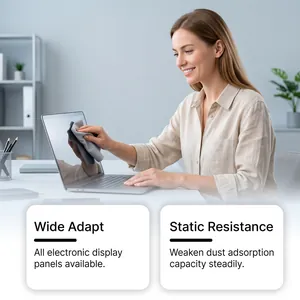 Woman cleaning a laptop screen with a gray microfiber cloth in a bright office.