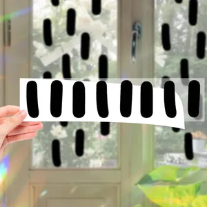 Vue détaillée des stickers muraux géométriques noirs ovales sur une vitre
