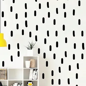 Vue détaillée de stickers muraux noirs abstraits sur une décoration murale blanche