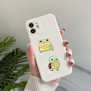 Close-up of cute frog and turtle motivational stickers on a white phone case.