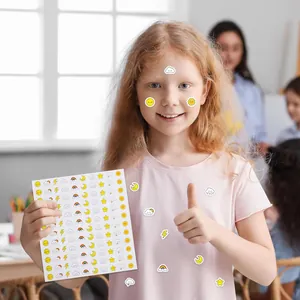 Niña sosteniendo una hoja de 120 mini pegatinas de clima con diseños de caritas