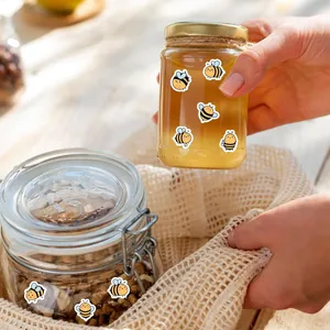 Primer plano de lindas pegatinas de abejas decorando tarros de cristal con miel y nueces
