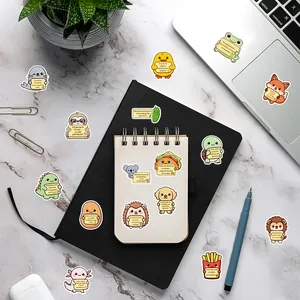 Collection of Spanish motivational animal stickers on stationery and laptop surfaces