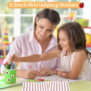 Close-up of 0.5 inch mini ladybug stickers being used by a mother and child for DIY art.