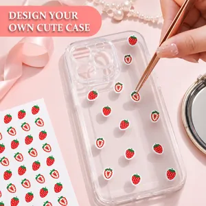 Detalle de mini pegatinas de fresas aplicadas a una funda de móvil con pinzas