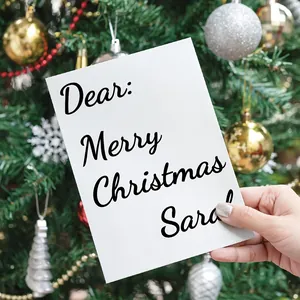 Close-up detail of a personalized Christmas greeting sticker on a white DIY card