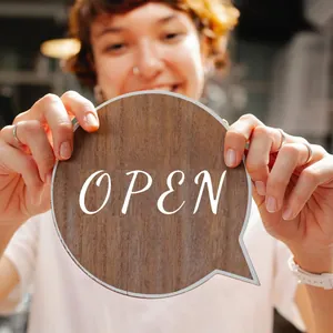Κοντινό πλάνο λευκού DIY αυτοκόλλητου 'OPEN' σε χειρόγραφη γραφή σε ξύλινη πινακίδα