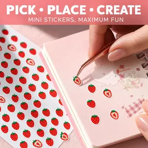 Primer plano de lindas pegatinas de mini fresas aplicadas en una agenda rosa.
