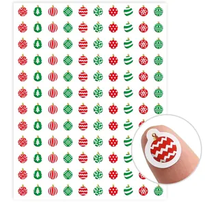 Primer plano de mini pegatinas festivas que muestran el tamaño en la punta del dedo