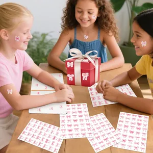 Detailopname van roze strikstickers die door kinderen op cadeaus worden gebruikt.