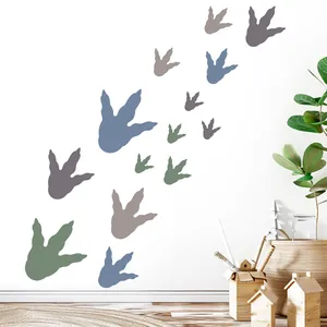 Nursery wall decor featuring colorful dinosaur footprint stickers in a playroom