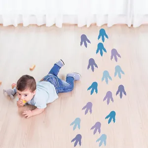 Dinosaur footprint floor stickers in a nursery setting with a crawling baby detail view