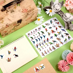 A detailed view showing 2.5cm waterproof hummingbird and bird stickers applied to a notebook.